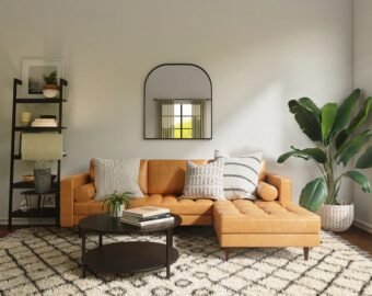 A modern living room with a tan corner sofa, patterned cushions, a round black coffee table, large patterned rug, potted plant, black shelf with decor, and wall mirror—ideal for company lets London or an Elite Property London guaranteed rent scheme.
